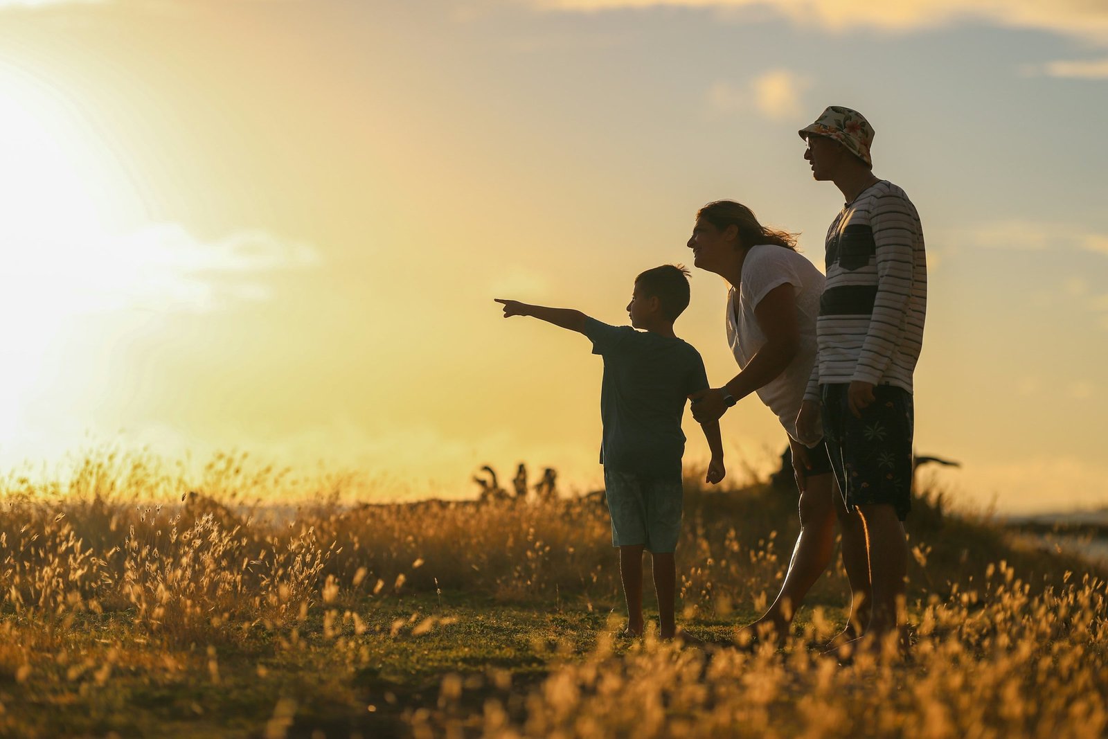 Eine Familie mit Kind blickt gemeinsam in die Abendsonne